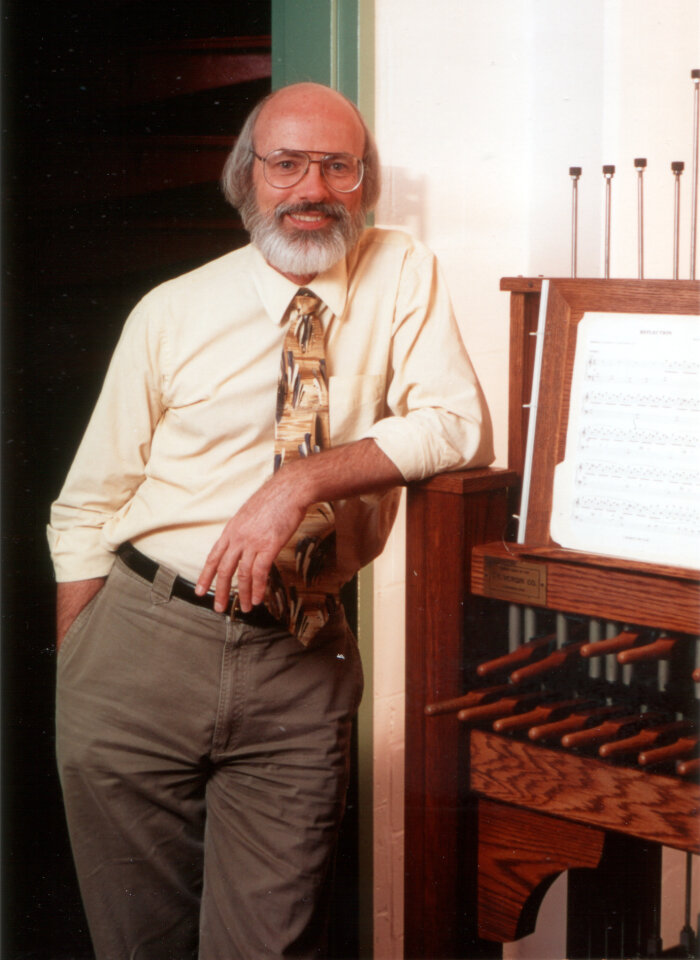 Herr mit Brille und farbiger Krawatte an einem Stockenklavier.