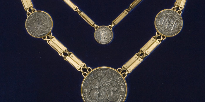 Zweigeteilte, goldene Kette mit sechs eingearbeiteten Münzen.