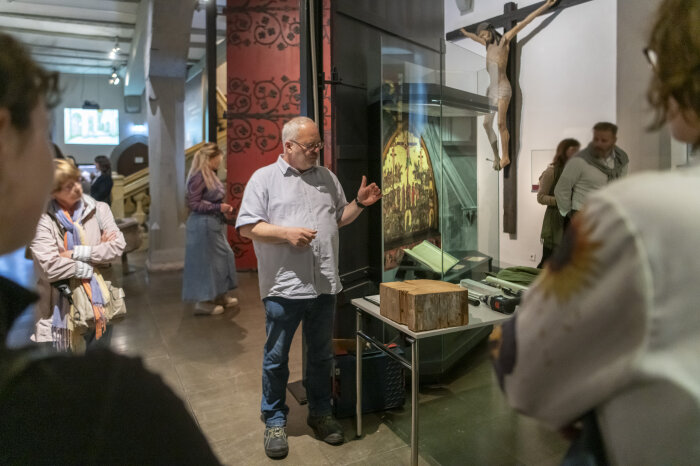Erklärungen an einer Vitrine vor Besuchern