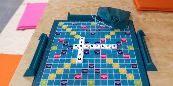 Auf einem Spielbrett ist mit weißen Steinen der Name „Mirjam Pressler“ aufgelegt. 