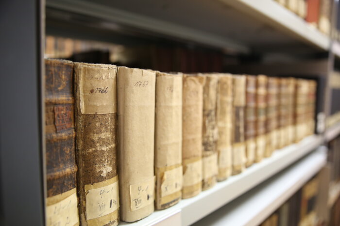 Historische Bücher in einem Archivregal
