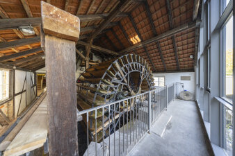 großes Wasserrad im Inneren einer Mühle