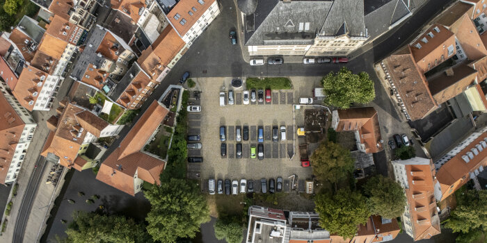 Luftaufnahme eines Parkplatzes inmitten städtischer Bebauuung