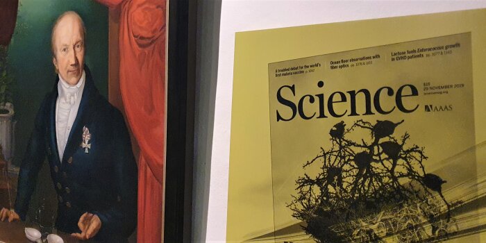 Historisches Porträt eines Mannes hängt neben einem alten Zeitschrift-Cover der Zeitschrift "Science".