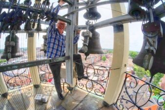 Foto: Carillonneur Toni Rats auf dem Glockenturm © Privataufnahme Ein Mann mit schwarzer Brille und blauem Karohemd positioniert sich in einem Turmglockenspiel
