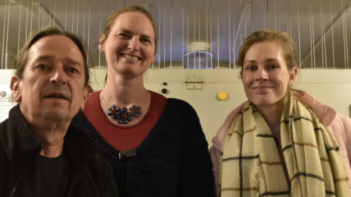 Ein Mann und zwei Frauen in winterlicher Kleidung vor dem Spieltisch des Erfurter Carillons