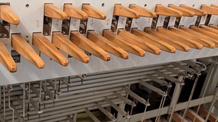 Tasten des Stockenklaviers am Erfurter Carillon Mehrere Tasten aus hellem Holz in ihrer Spielvorrichtung