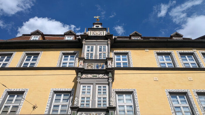 Historisches Gebäude in Erfurt mit gelber Fassade und Blick in den Himmel