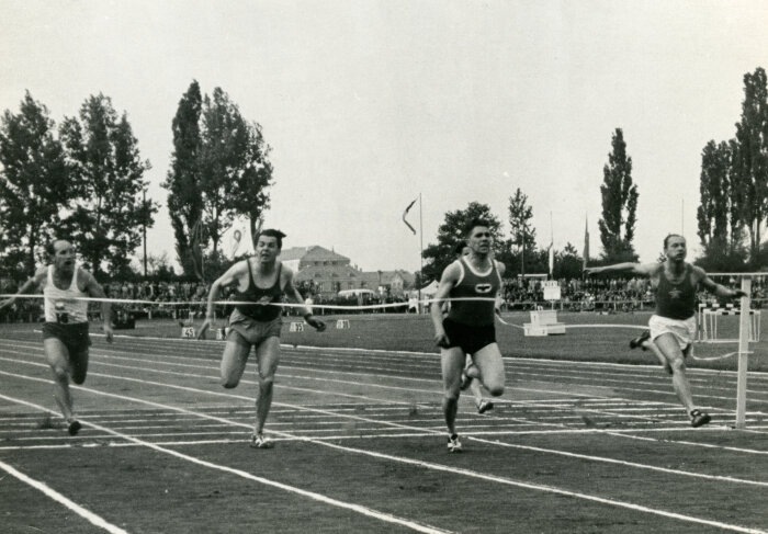 Vier Läufer an der Ziellinie bei einer Sportveranstaltung im Jahr 1955