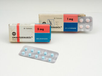 Zwei weiß-rot-blaue Faltschachteln mit Aufdruck „Oral-Turinabol“ blaue 5 mg und rote 1 mg Tabletten.