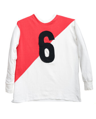Weißes Langarm-Trikot mit einer schwarzen Nr. 6, roten Stoffeinsatz von der rechten Schulter bis zur linken Hüfte.