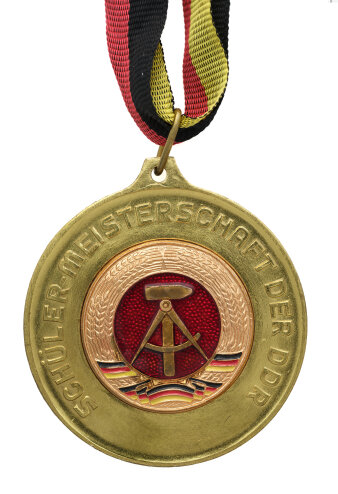 Goldmedaille mit farbigem Wappen der DDR und der Inschrift „Schülerimeisterschaft der DDR“ 