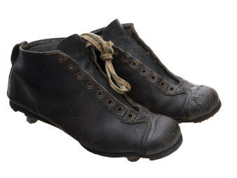 Schwarze Fußballschuhe aus Leder mit Stollen an der Sohle und weißen Schnürsenkeln