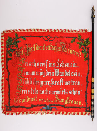 Rote Fahne mit dem Leitspruch des „Turn-Verein Ilversgehofen“ umrahmt von Eichenzweigen.