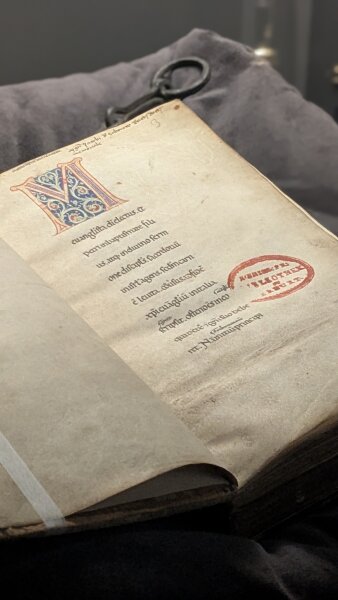 Buchseite einer historischen Handschrift mit einer bunt verzierten Initiale M