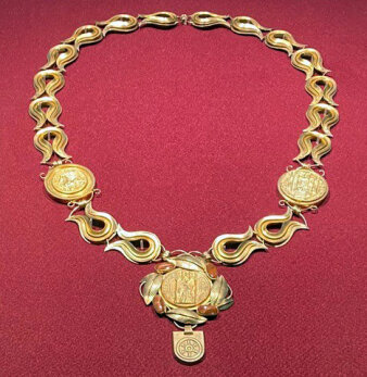 Historische Goldkette einer hochrangigen Person auf rotem Grund