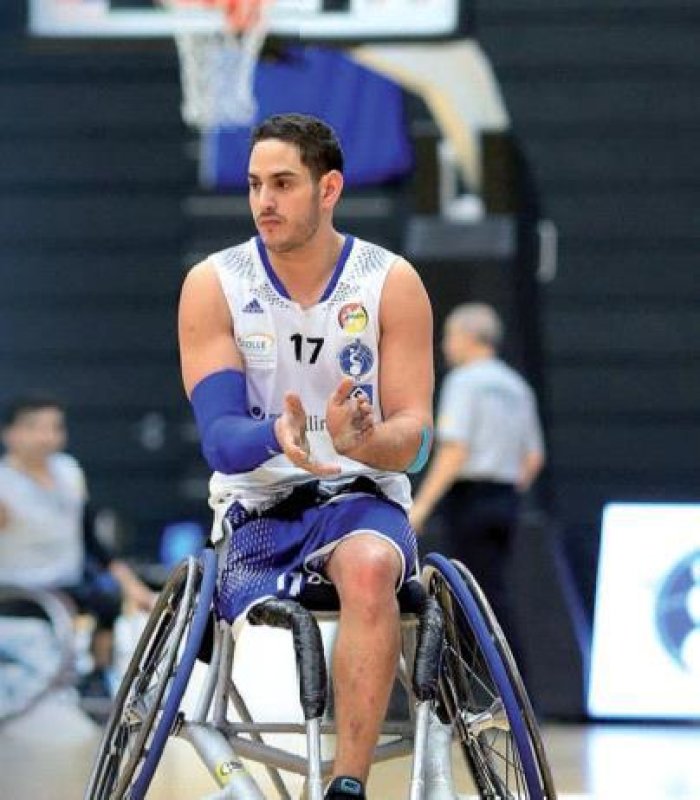 ein Mann mit einem Bein in einem Rollstuhl auf einem Basketballfeld