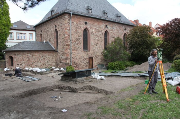 Ausgrabungen im Synagogenbezirk Worms Ausgrabung in Worms, im Vordergrund eine Person, die technische Aufnahmen macht.