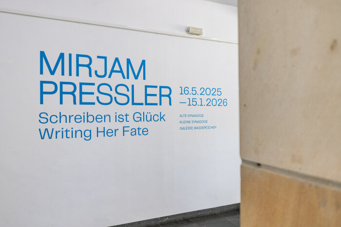 Blauer Schriftzug auf einer weißen Wand