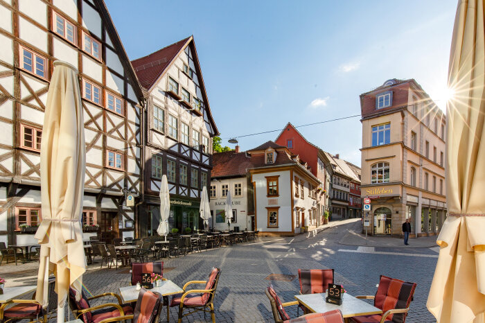Gepflasterter Platz umringt von Fachwerkhäusern und dem Eingang zur Erfurter Krämerbrücke
