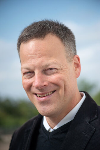 Lächelnder Mann mit kurzen grauen Haaren