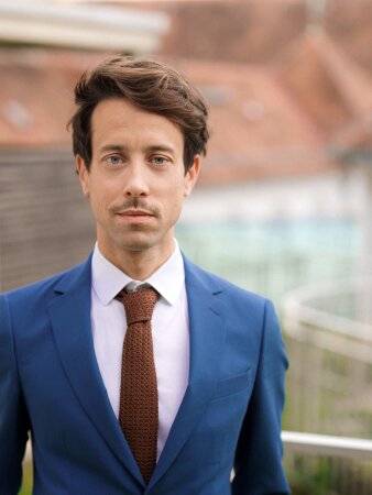 Junger Mann im blauen Anzug mit brauner Krawatte