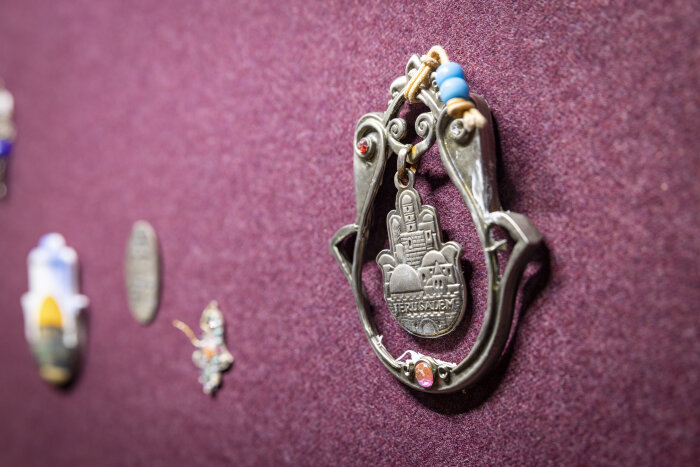 Ein Amulett, das Mittelstück hat die Form einer Hand und trägt eine Prägung der Stadt Jerusalem.Collage aus hunde