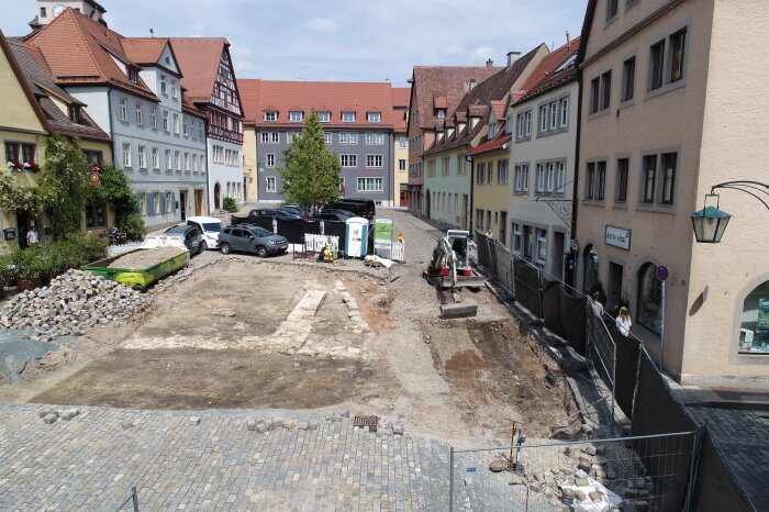 Ausgrabungsstätte mit Bagger inmitten von Wohnhäusern