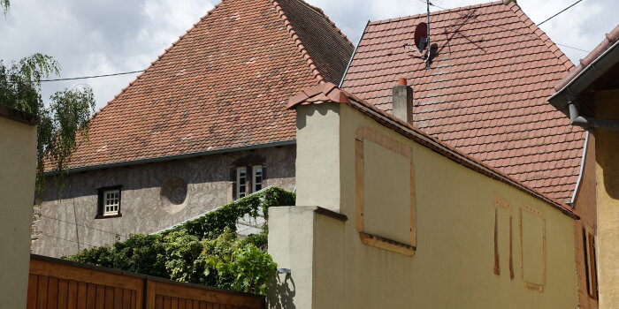 Historisches Gebäude versteckt hinter einer gelben Mauer