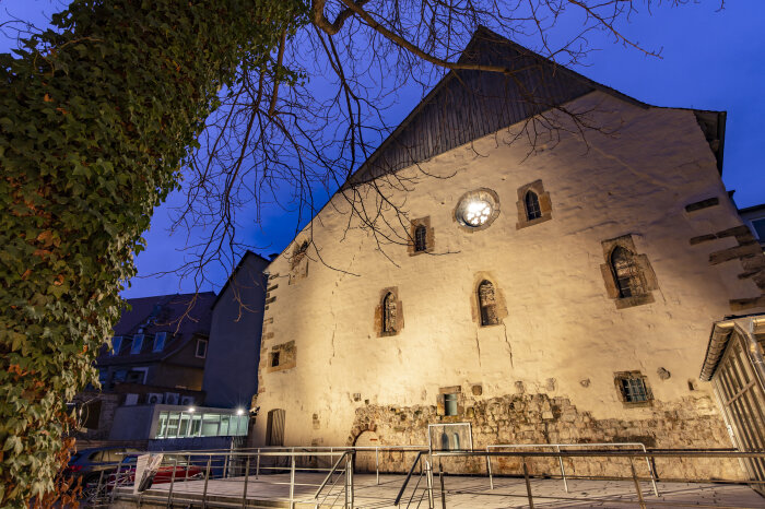 Licht gegen Dunkelheit - Alte Synagoge beleuchtete Fassade eines mittelalterlichen Gebäudes in der Dämmerung