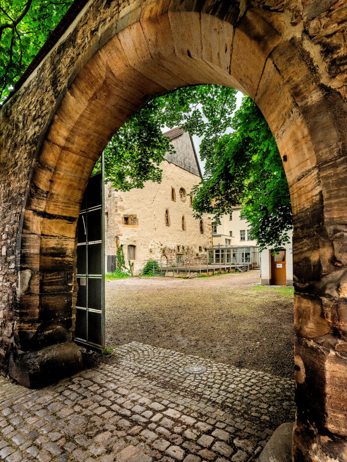 Alte Synagoge Erfurt mit Torbogen Gemauerter Torbogen mit einem historischen Gebäude in einem Hof umringt von Bäumen im Hintergrund