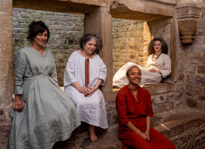 Lucidarium / Ritual Echoes Frauen in mittellaterlichen Gewändern auf einer Mauer sitzend