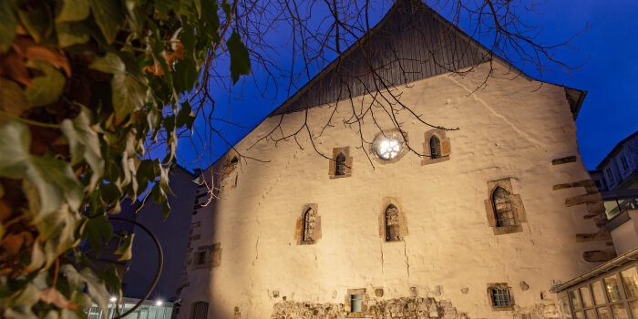 beleuchtetes Gebäude mit steinerner Fassade in der Dämmerung