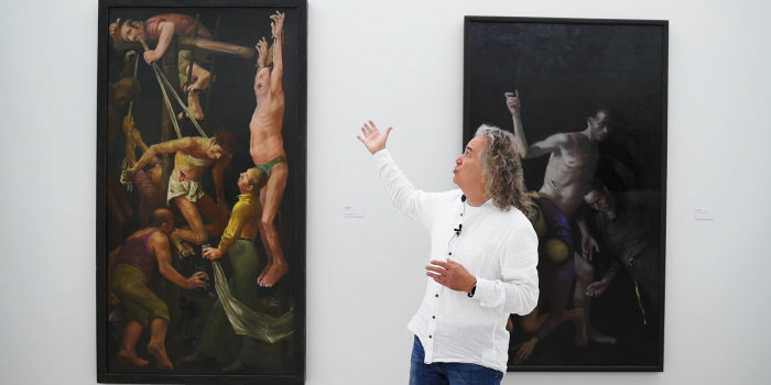 ein Mann erklärt ein Bild in einer Ausstellung
