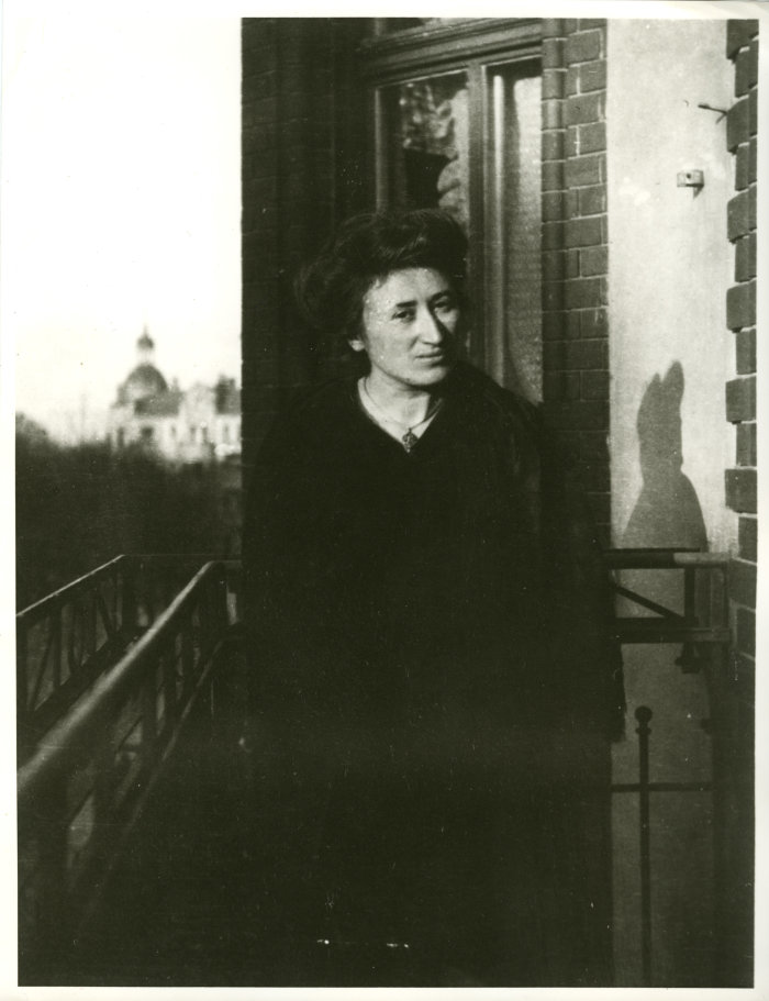 Eine junge Frau steht auf einem Balkon. 
