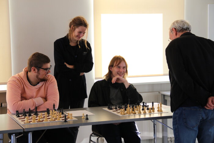 Vier Personen spielen Schach