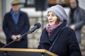 Foto: Die Oberkuratorin des Erinnerungsortes PD Dr. Annegret Schüle führte durch die Gedenkstunde. © Stadtverwaltung Erfurt Frau mit Mütze und Brille die eine Rede hält