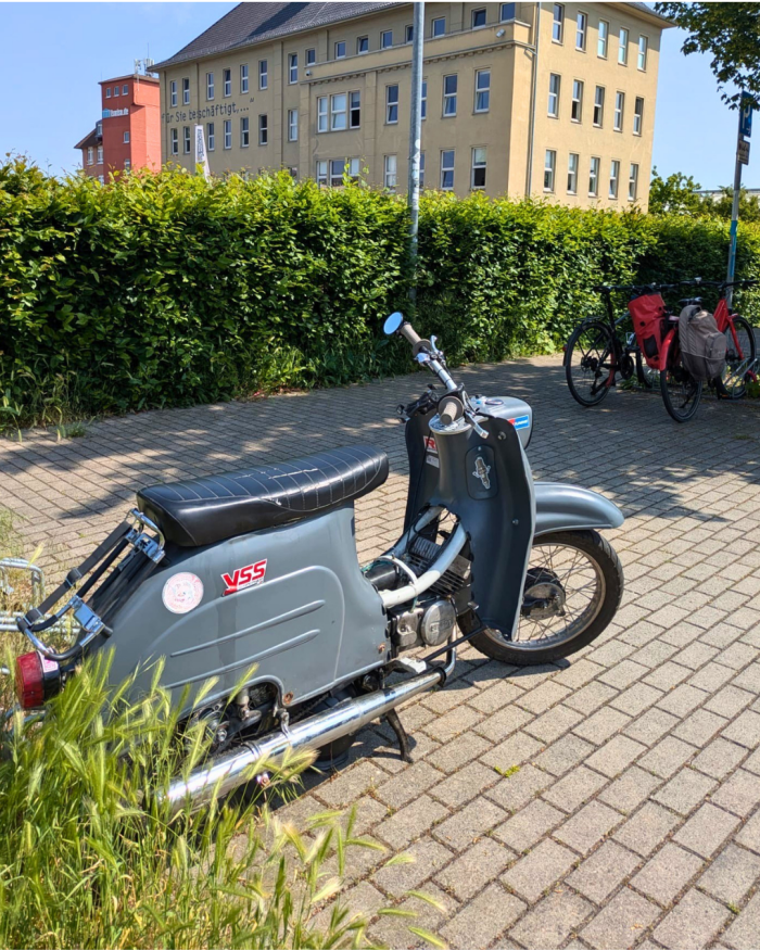 Eine graue Simson Schwalbe vor dem Gebäude des Erinnerungsort Topf und Söhne