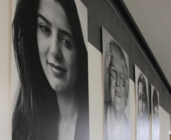 Ausdrucke von Schwarz-Weiß-Fotos und Texten hängen an den Wänden eines Raumes