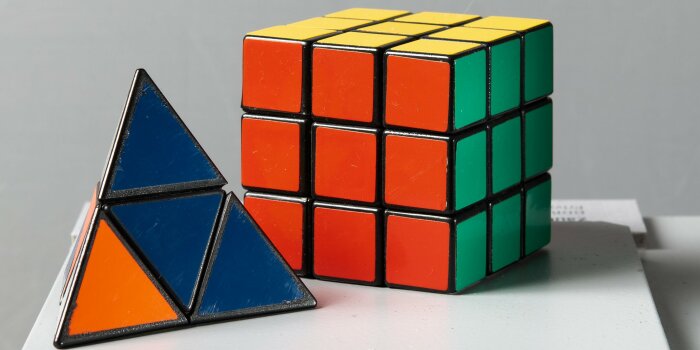 Ein Würfel mit farbigen Flächen sowie ein Dreieck, das ebenfalls aus farbigen Flächen besteht